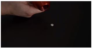Twisting the handle until the tablet is ejected.