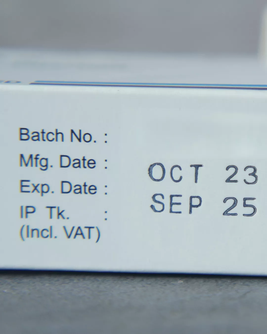 A close up of a packaged pharmaceutical product with the batch number, manufacturing date, and expiration date.